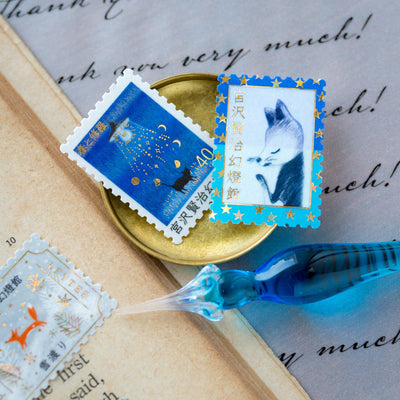 Postage flake stickers in a match box -The Snow Crossing -