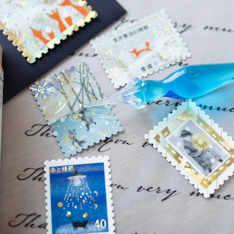 Postage flake stickers in a match box -The Snow Crossing -