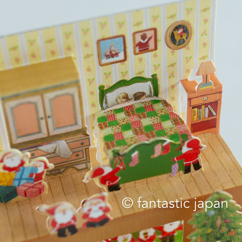 Christmas pop up card -Santa Clauses relaxing in the house-