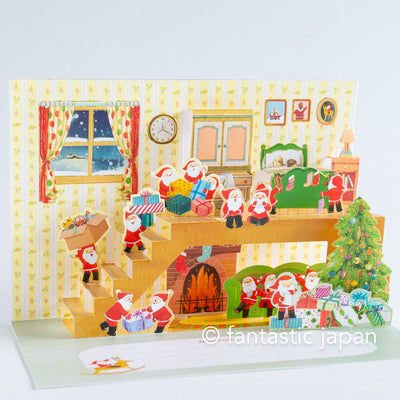 Christmas pop up card -Santa Clauses relaxing in the house-